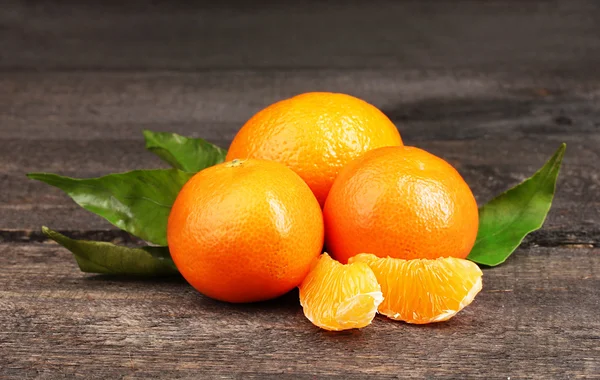 Tangerines with leaves on wooden grey table — Stok fotoğraf