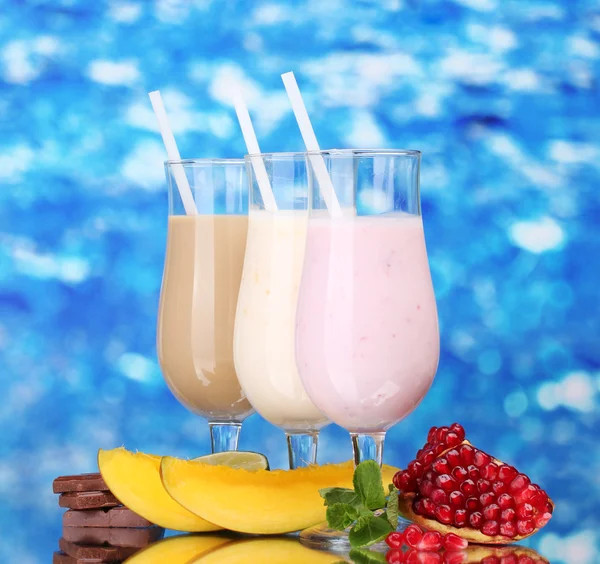 Batidos de leite com frutas e chocolate no fundo azul — Fotografia de Stock