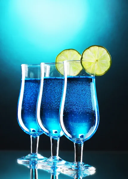 Blauer Cocktail in Gläsern mit Limette auf blauem Hintergrund — Stockfoto