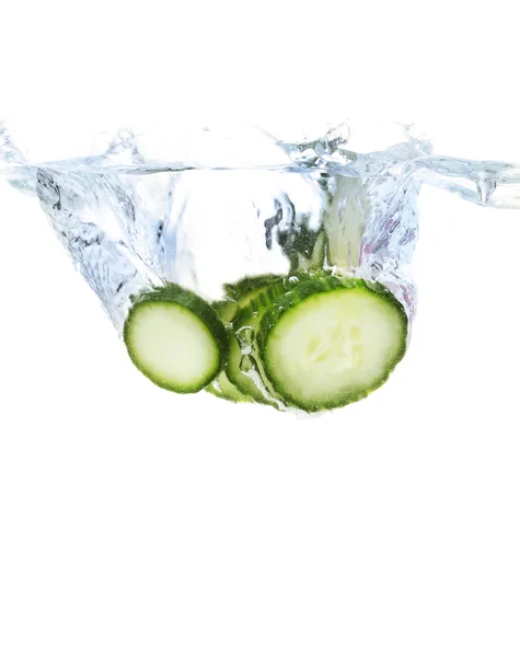 Čerstvé krájené okurky ve vodě izolovaných na bílém — Stock fotografie
