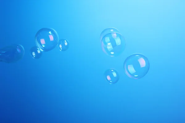 Мыльные пузыри на голубом фоне — стоковое фото