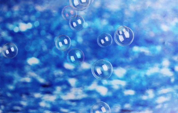 Soap bubbles on blue background — Stock Photo, Image