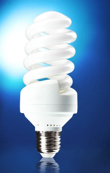 Lampada a risparmio energetico su sfondo blu — Foto Stock