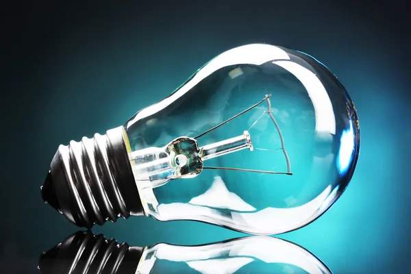 Light bulb on blue background — Stock Photo, Image