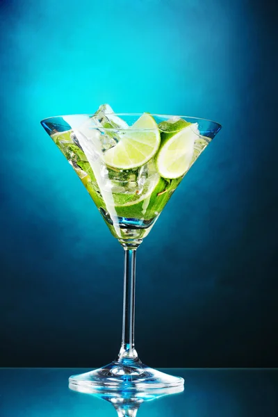 Glas Cocktail mit Limette und Minze auf blauem Hintergrund — Stockfoto