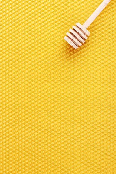 Žlutá krásná honeycomb a dřevěné honey drizzler — Stock fotografie