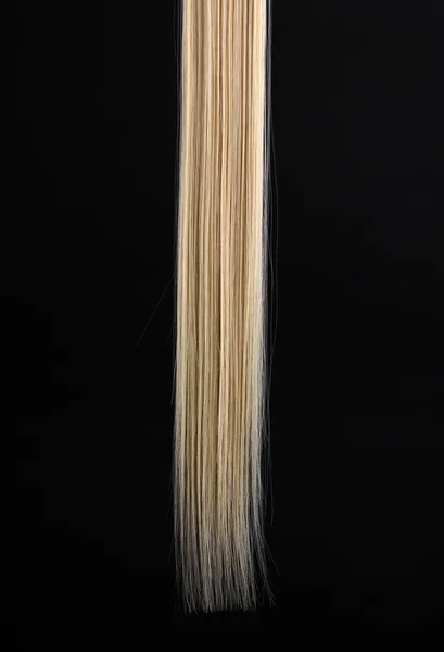 Shiny blond hair isolated on black — Stock Photo, Image