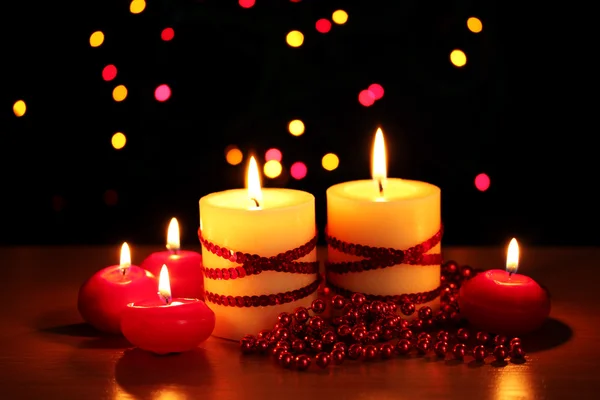 Belle candele e decorazioni su tavolo in legno su sfondo luminoso — Foto Stock
