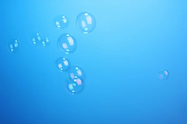 Bulles de savon sur fond bleu — Photo