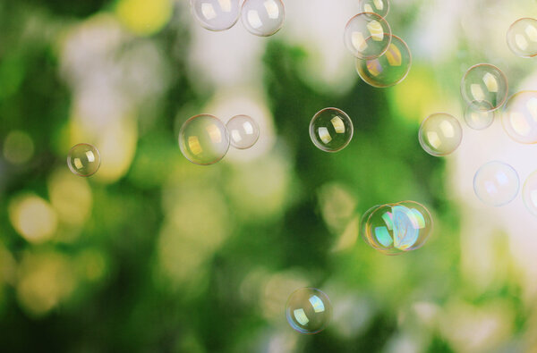 Soap bubbles on green background