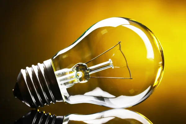 Light bulb on yellow background — Stock Photo, Image