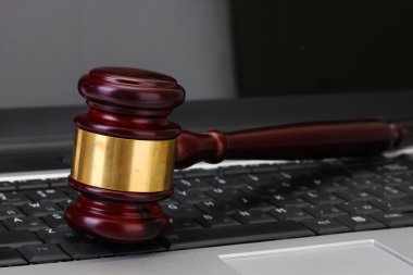 Wooden gavel on laptop computer close up clipart