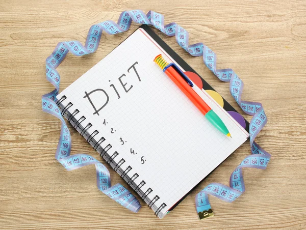 Planificación de la dieta. Cinta métrica portátil y bolígrafo en mesa de madera — Foto de Stock