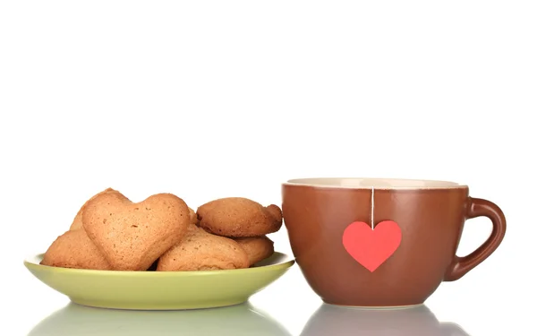 Copa marrón con bolsa de té y galletas en forma de corazón en placa verde aislado en — Foto de Stock