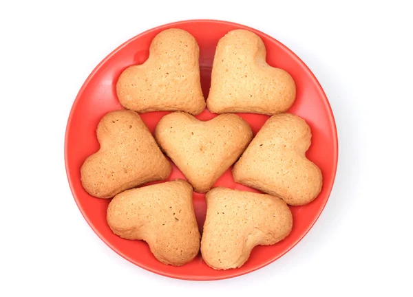 Καρδιά σχήμα cookies στον κόκκινο πιατάκι απομονωθεί σε λευκό — Φωτογραφία Αρχείου