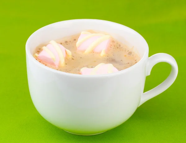 Tasse Cappucino mit Marshmallows auf grünem Hintergrund — Stockfoto