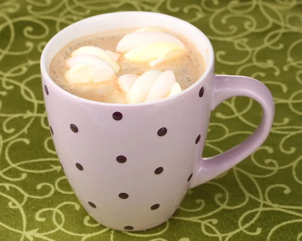 Kopje cappuccino met marshmallows op groene tafellaken — Stockfoto