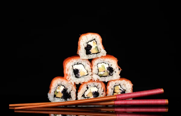 Tasty rolls with chopsticks isolated on black — Stock Photo, Image