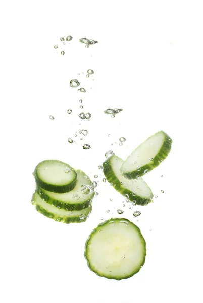 stock image Fresh sliced cucumber in water isolated on white