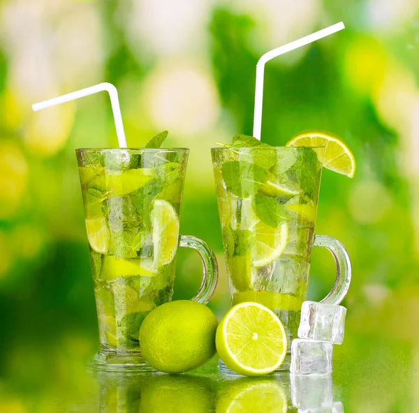 Glazen cocktail met limoen en munt op groene achtergrond — Stockfoto
