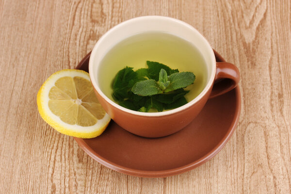 Мятный чай с мятой и лимоном на деревянном фоне
