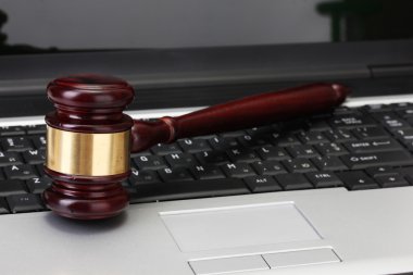 Wooden gavel on laptop computer close up clipart