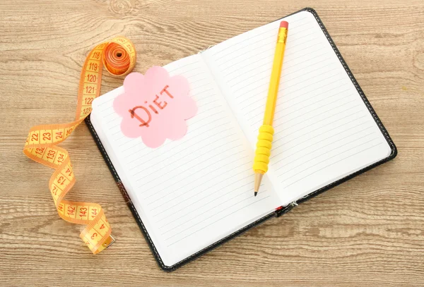 Planning van dieet. laptop meten tape en pen op houten tafel — Stockfoto