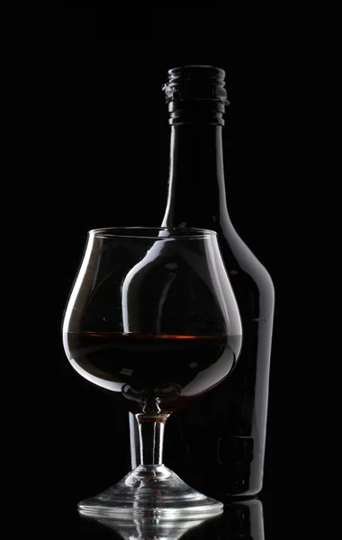 白兰地和黑色背景上的瓶玻璃 — 图库照片