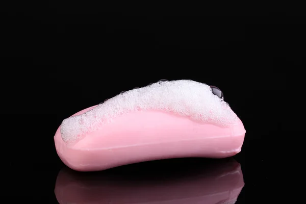 Sabão rosa com espuma isolada em preto — Fotografia de Stock