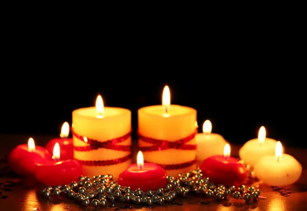 美丽的蜡烛和黑色背景上的木桌上的装饰 — 图库照片