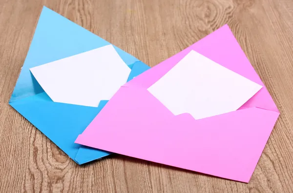 Цветные конверты на деревянном фоне — стоковое фото
