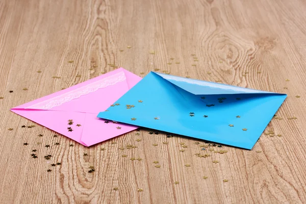 Color envelopes and confetti on wooden background — Stock Photo, Image