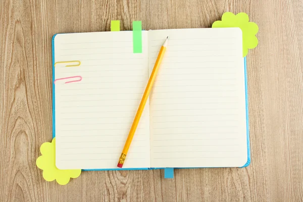 Open note book with stickies and pencil on wooden background — Stock Photo, Image