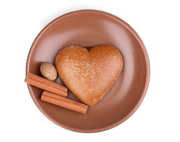 Biscotto a forma di cuore con cannella e noce moscata su piattino isolato su bianco — Foto Stock