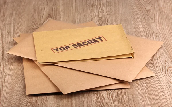 Φάκελοι με κορυφαίο μυστικό σφραγίδα σε ξύλινα φόντο — Φωτογραφία Αρχείου