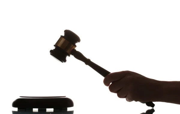 Wooden gavel in hand on gray background — Stock Photo, Image