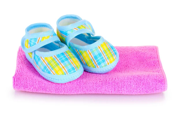 Blue baby slofjes op roze handdoek geïsoleerd op wit — Stockfoto