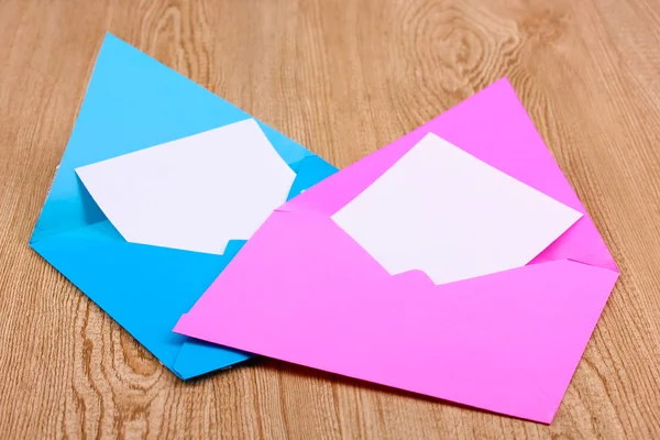 Envelopes de cor em fundo de madeira — Fotografia de Stock
