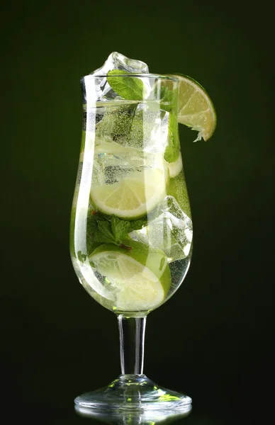 Glas Cocktail mit Limette und Minze auf grünem Hintergrund — Stockfoto