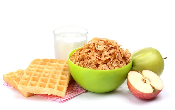 Смачні кукурудзяні пластівці в зеленій мисці, яблука і склянка молока ізольовані на білому — стокове фото