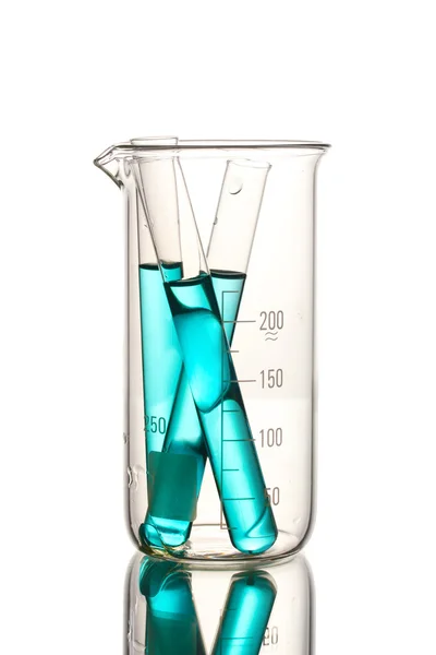 Лабораторные трубки с голубой жидкостью в измерительном стакане с отражением изолы — стоковое фото