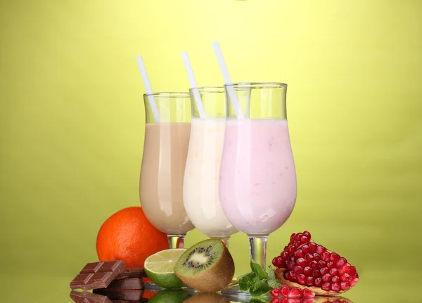 Milk shakes with fruits and chocolate on green background — Stock Photo, Image