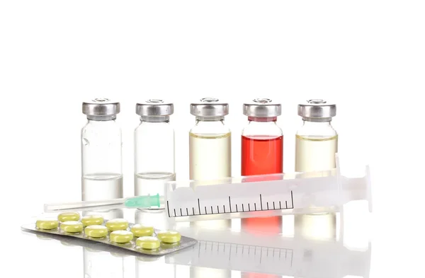 Шприц с медицинскими ампулами и таблетками, изолированными на белом — стоковое фото