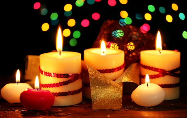 Belle candele su tavolo di legno su sfondo luminoso — Foto Stock