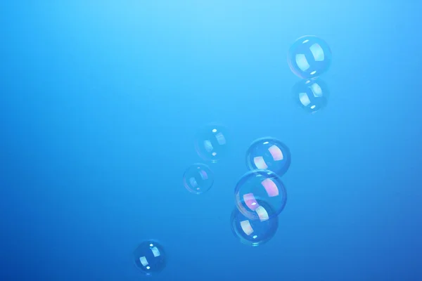 Burbujas de jabón sobre fondo azul — Foto de Stock