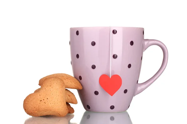 Tasse rose avec sachet de thé et biscuits en forme de coeur isolés sur blanc — Photo