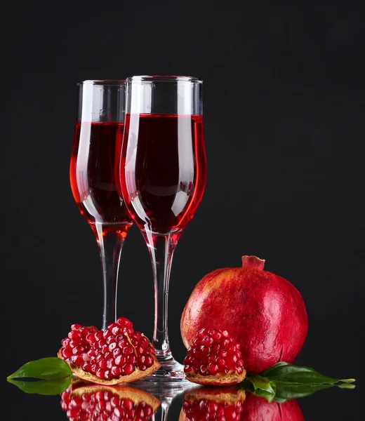 Ripe pomergranate and glasses of wine on black background — Stock Photo, Image