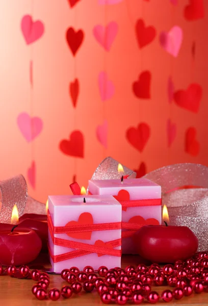 Ljus för alla hjärtans dag på träbord på röd bakgrund — Stockfoto