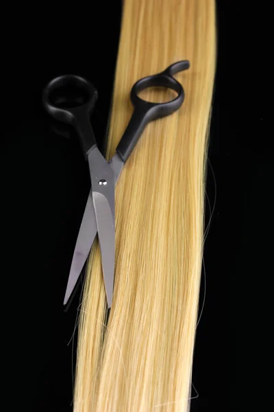 Λαμπερά ξανθά μαλλιά και μαλλιά κοπής λαμαρινοψάλιδα απομονώνονται σε μαύρο — Φωτογραφία Αρχείου