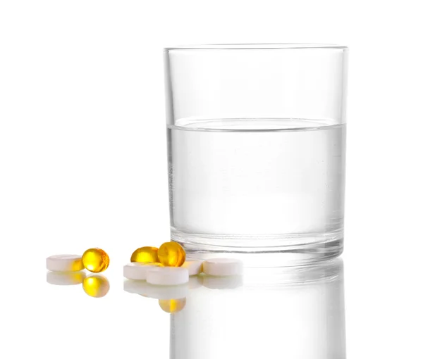 Glas Wasser und Pillen isoliert auf weiß — Stockfoto